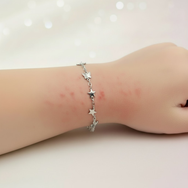 Kinderhandgelenk mit einem Kinderarmband, die Haut wirkt leicht gerötet, Fokus auf empfindliche Kinderhaut und Schmuck