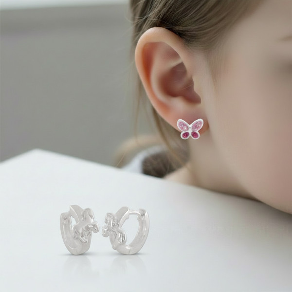 Kinderohr mit kleinem Ohrstecker, daneben aufgelegte Klapp-Creolen