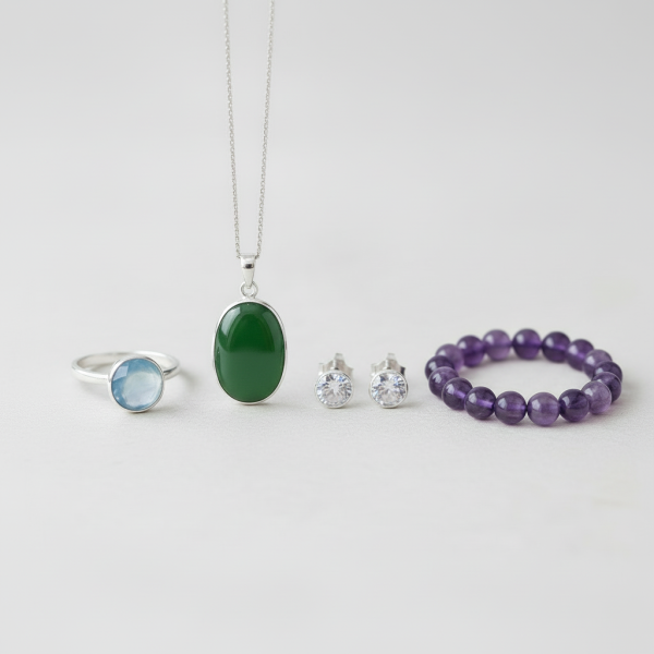 Edelstein-Ring, Anhänger, Ohrringe und Kugelarmband nebeneinander arrangiert, als Übersicht über unterschiedliche Fassungsarten für verschiedene Schmuckstücke